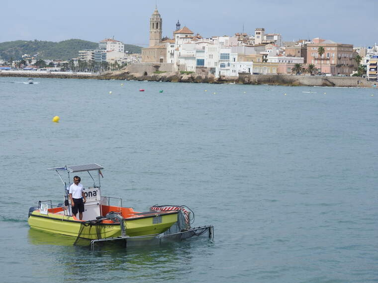 L'embarcació de recollida de residus davant de Sitges