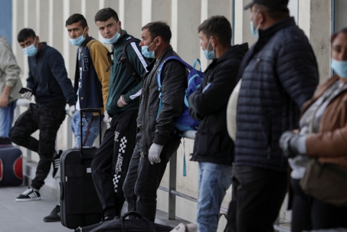 Treballadors temporals romanesos esperen per volar a Alemanya, aquest divendres a l'aeroport de Bucarest (Reuters)